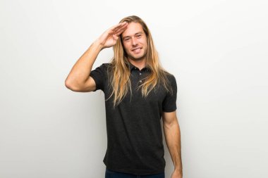 Beyaz duvar el ile selamlayan üzerinde uzun saçlı sarışın adam