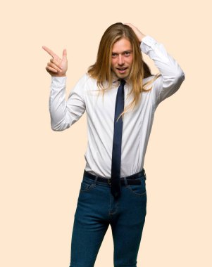 Parmak tarafına işaret ve bir ürün yalıtılmış zemin üzerine sunma uzun saçlı sarışın iş adamı