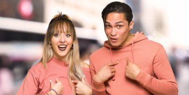 Şehirde sürpriz yüz ifadesi ile genç çift