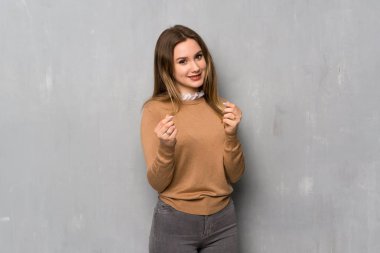 Genç kız para jest yapma dokulu duvar üzerinde