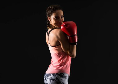 Boks eldivenleri ile koyu arka plan üzerinde spor kadın