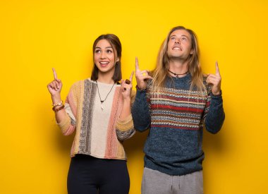 Hippi çift sarı arka plan işaret parmağı ile harika bir fikir üzerinde