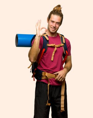 Bir ok işareti parmak ile izole arka plan üzerinde gösterilen dağ backpacker adamla uzun yürüyüşe çıkan kimse