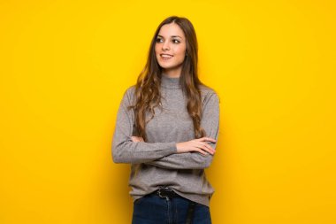 Genç kadın gülümseyerek süre geçti silah tutmak sarı duvarın üzerinden