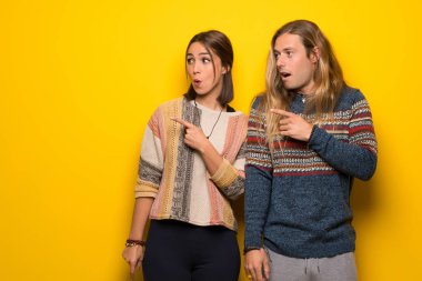 Hippi çift sarı üzerinde şaşırmış ve işaret yan arka plan