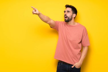 Sarı duvar uzağa işaret içinde yakışıklı adam