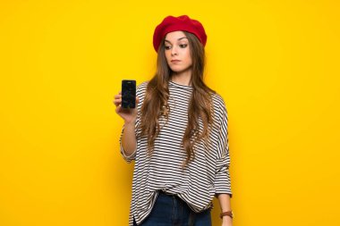 Kızla Fransız tarzı sarı duvardan sorunlu holding smartphone kırık