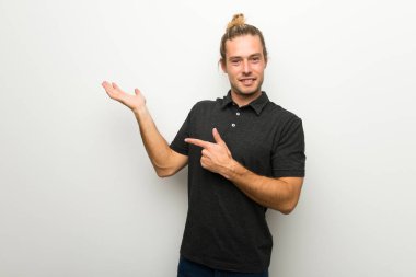 Beyaz boşaltmak hayali avuç içinde tutarak duvarın üzerinden uzun saçlı sarışın adam bir reklam eklemek için