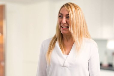 Biraz gergin ve korkmuş diş evde basarak orta yaş beyaz gömlek sarışın kadınla