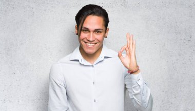 Dokulu duvar arka planda parmakları ile ok işareti gösteren yakışıklı adam