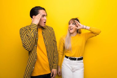 Canlı sarı arka plan üzerinde Genç çift sadece bir şey fark etti ve çözüm niyetinde