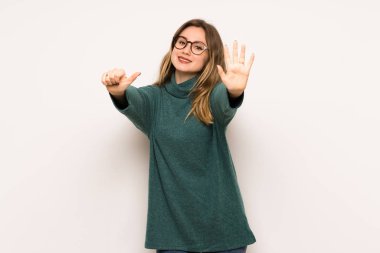 Genç kız beyaz duvar altı parmak ile sayma üzerinde