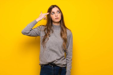 Genç kadın intihar jest yapma sorunları olan sarı duvarın üzerinden