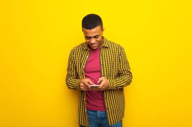 Mobil ileti gönderme Sarı zemin üzerine genç afro Amerikalı adam