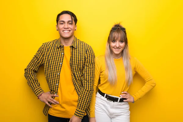 Junges Paar Vor Leuchtend Gelbem Hintergrund Posiert Mit Armen Der — Stockfoto