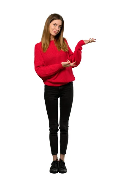 分離の白い背景の上に来るに招待側に手を拡張する赤いセーターを持つ若い女性のフルレングス ショット — ストック写真