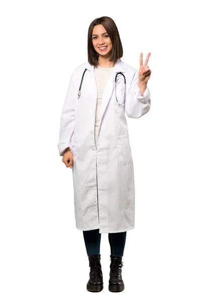 一个年轻的医生妇女微笑和显示胜利标志在孤立的白色背景的全长镜头 — 图库照片