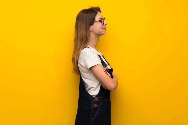 Mujer Sobre Pared Amarilla Posición Lateral —  Fotos de Stock