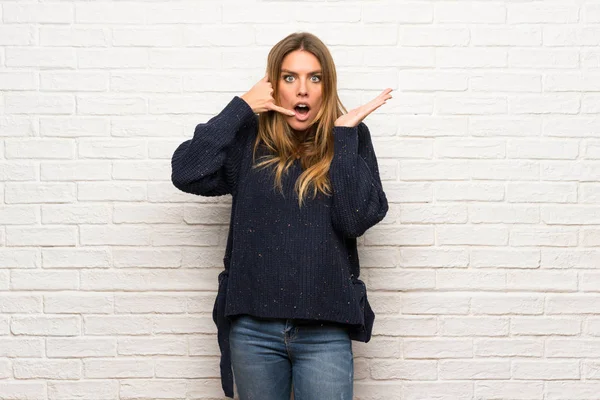 Mujer Rubia Sobre Pared Ladrillo Haciendo Gesto Teléfono Dudando —  Fotos de Stock