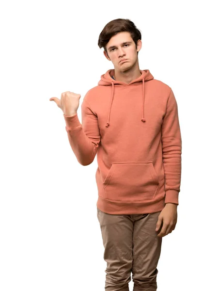 Tonåringen Man Med Sweatshirt Olycklig Och Pekar Sidan Över Isolerade — Stockfoto