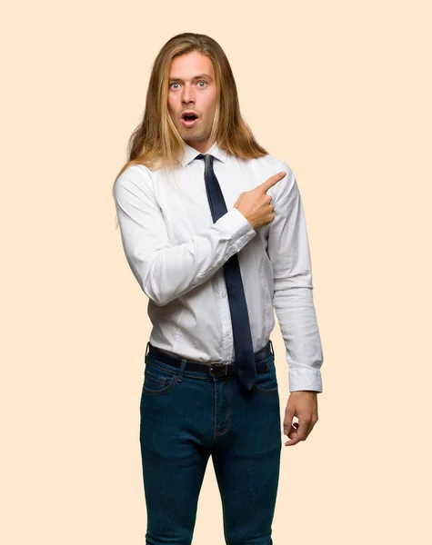 Blond Businessman Long Hair Surprised Pointing Side Isolated Background — Stock Photo, Image