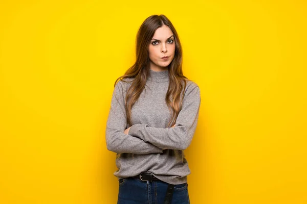 不調を感じる黄色の壁の上の若い女性 — ストック写真