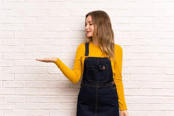 Genç kız boşaltmak hayali avuç içinde holding beyaz tuğla duvarın üzerinden bir reklam eklemek için