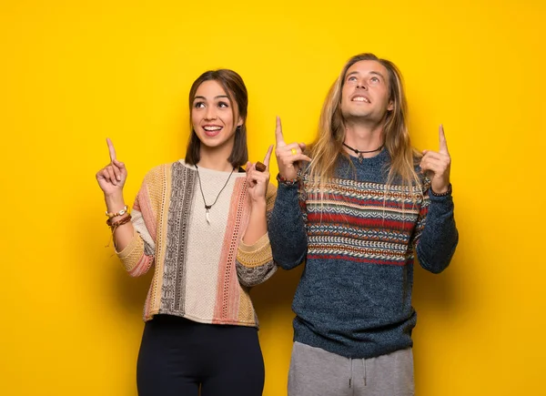 Hippi çift sarı arka plan işaret parmağı ile harika bir fikir üzerinde