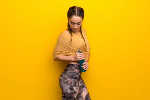 Mujer Deportiva Sobre Fondo Amarillo Vibrante Con Una Botella —  Fotos de Stock