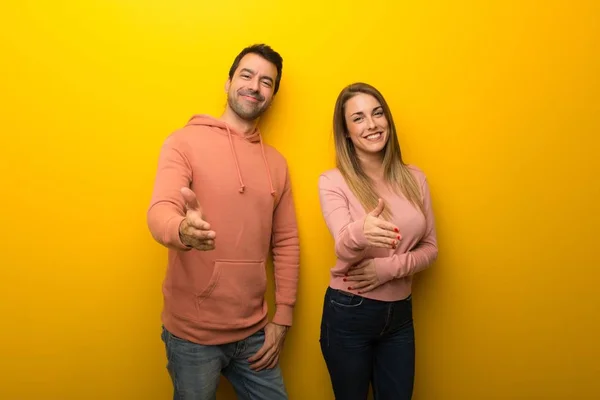 Grupo Duas Pessoas Fundo Amarelo Apertando Mãos Para Fechar Bom — Fotografia de Stock