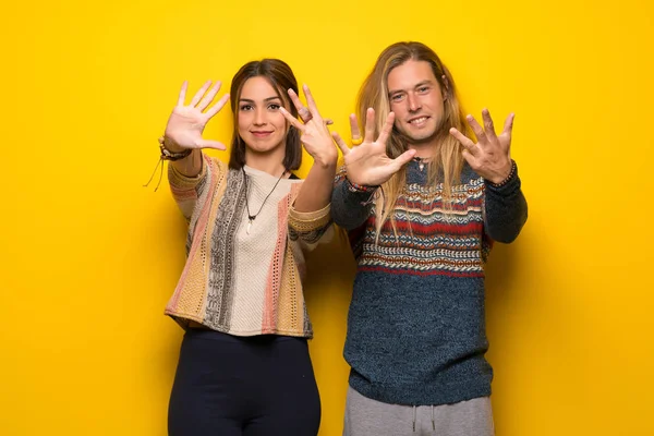 Hippi çift dokuz parmaklı sayma sarı arka plan üzerinde