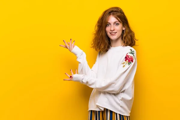 Giovane Donna Rossa Sopra Muro Giallo Che Estende Mani Lato — Foto Stock