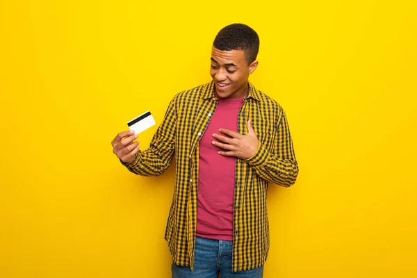Afro American Młodzieńca Żółtym Tle Posiadania Karty Kredytowej Zaskoczony — Zdjęcie stockowe