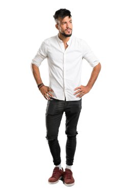 Beyaz tişörtlü, kuşkulu ve izole edilmiş beyaz arka planda kafası karışmış Arap bir gencin tam boy fotoğrafı.