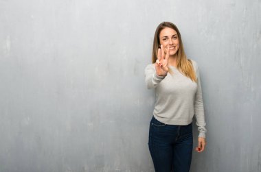 Dokulu duvar mutlu ve sayım üç parmak ile genç kadın