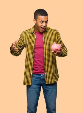 Genç afro Amerikalı adam izole arka plan üzerinde bir servet tutarken sürpriz