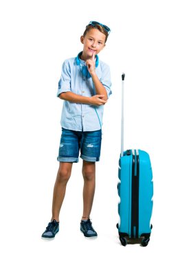 Çocuk tam vücut güneş gözlüğü ve kulaklık bavulunu izole beyaz zemin üzerine gülen ile seyahat ile