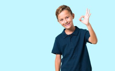 Küçük çocuk bir ok işareti parmak ile mavi arka plan üzerinde gösterilen