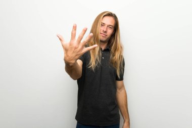 Beyaz duvar beş parmak ile sayma üzerinde uzun saçlı sarışın adam