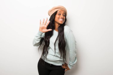 Genç afro Amerikalı kadın beyaz duvar beş parmak ile sayma