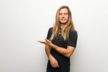 Beyaz duvar görünümlü doğru gülümseyen iken bir fikir sunmak üzerinde uzun saçlı sarışın adam