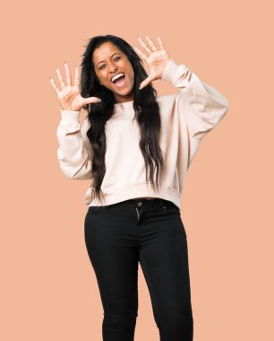 Genç afro Amerikalı kadın on ile izole kahverengi zemin üzerinde parmak sayma