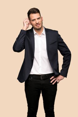 Koyu sarı arka plan üzerinde şüpheleri yakışıklı iş adamı