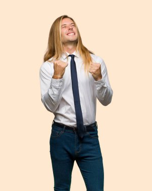 Kazanan pozisyon izole arka plan üzerinde bir zaferini kutluyor uzun saçlı sarışın iş adamı