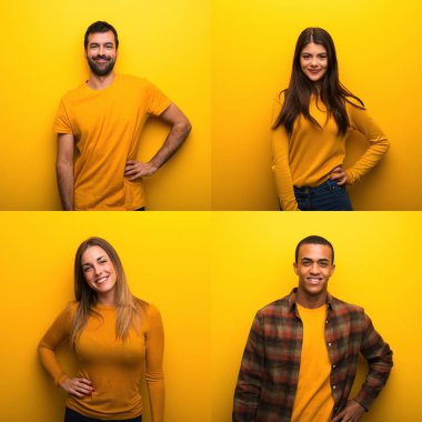 Kolları kalçasında poz veren ve gülümseyen insanlar.