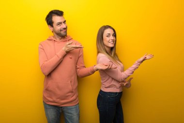 Grup eller yanına gelmek için davet için uzanan Sarı zemin üzerine iki insan