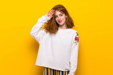 Sarı duvar el ile selamlayan üzerinde genç Kızıl saçlı kadın