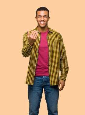 El ile gelmek davet genç afro Amerikalı adam. Mutlu izole arka plan üzerinde geldi