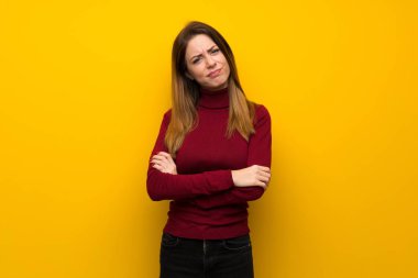 Balıkçı yaka üzerine sarı duvar duygu üzgün kadınla