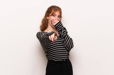 Birisi parmak ile işaret ve gülerek beyaz duvar genç Kızıl saçlı kadın